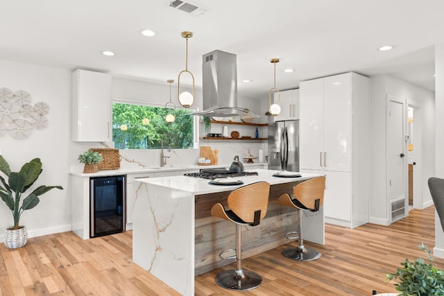 5102 Ravensdale Ln, Austin, TX 78723 - kitchen featuring wine cooler, island exhaust hood, stainless steel appliances, modern cabinets, and open shelves
