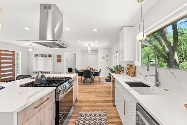 5102 Ravensdale Ln, Austin, TX 78723 - kitchen featuring appliances with stainless steel finishes, a sink, island exhaust hood, healthy amount of natural light, and recessed lighting
