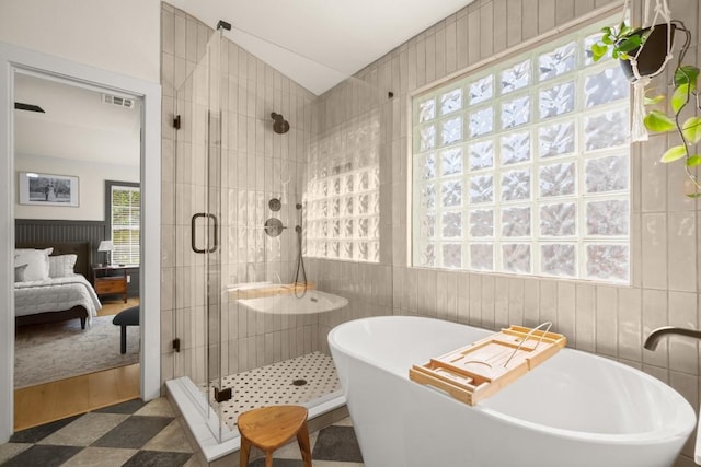 3400 Lynnbrook Dr, Austin, TX 78748 - full bathroom featuring connected bathroom, a shower stall, a freestanding tub, vaulted ceiling, and tile patterned floors