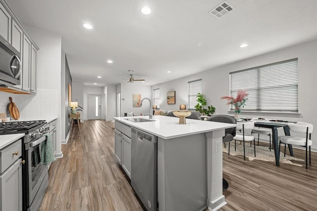7809 Linnie Ln, Austin, TX 78724 - kitchen with gray cabinetry, appliances with stainless steel finishes, wood finished floors, recessed lighting, and a ceiling fan