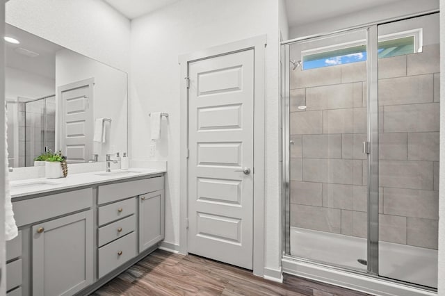 7809 Linnie Ln, Austin, TX 78724 - bathroom featuring double vanity, a stall shower, and wood finished floors