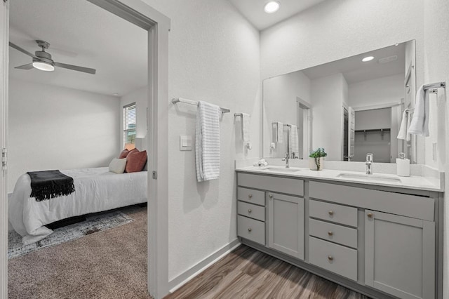 7809 Linnie Ln, Austin, TX 78724 - ensuite bathroom featuring double vanity, a ceiling fan, wood finished floors, a textured wall, and recessed lighting