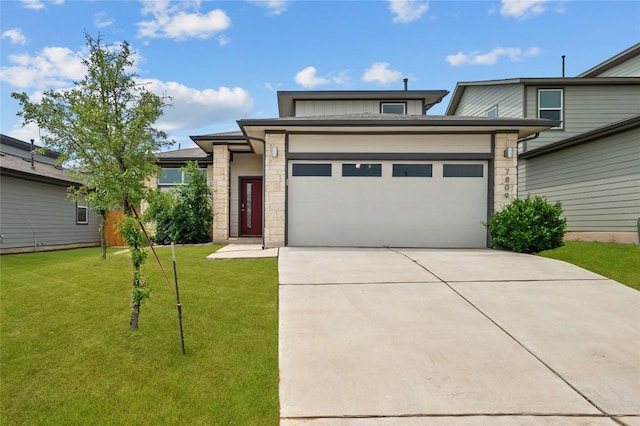 7809 Linnie Ln, Austin, TX 78724 - view of front of house featuring an attached garage, driveway, a front yard, and stone siding