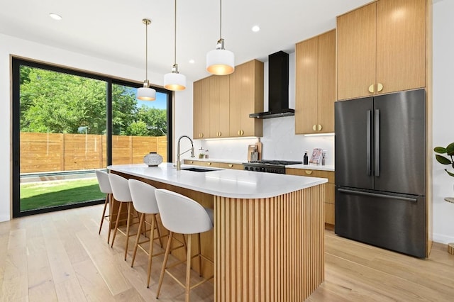 3507 Neal St Unit 1, Austin, TX 78702 - kitchen featuring freestanding refrigerator, wall chimney exhaust hood, a sink, light wood-style flooring, and recessed lighting