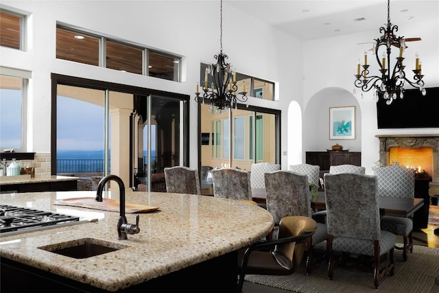 111 Piazza Vetta Dr, Austin, TX 78734 - dining area featuring a chandelier, arched walkways, a high ceiling, and a lit fireplace