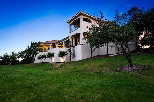 111 Piazza Vetta Dr, Austin, TX 78734 - view of side of home featuring a balcony, a lawn, stucco siding, and a tile roof