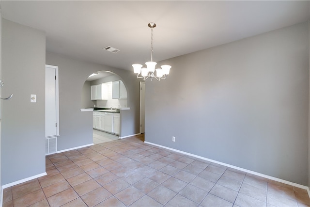 4303 Tamarack Trl, Austin, TX 78727 - unfurnished room featuring arched walkways, a chandelier, light tile patterned flooring, and baseboards
