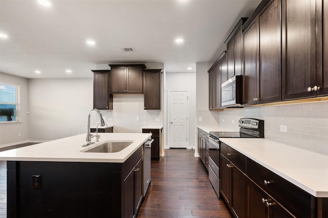 120 Flexus Ln, Liberty Hill, TX 78642 - kitchen featuring appliances with stainless steel finishes, a sink, dark wood finished floors, decorative backsplash, and dark brown cabinetry