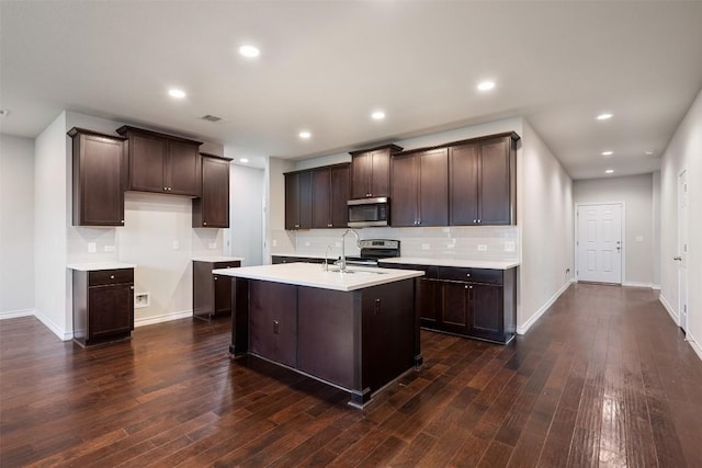 120 Flexus Ln, Liberty Hill, TX 78642 - kitchen featuring appliances with stainless steel finishes, a sink, dark brown cabinetry, dark wood finished floors, and backsplash