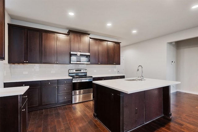 120 Flexus Ln, Liberty Hill, TX 78642 - kitchen with stainless steel appliances, a sink, dark wood finished floors, light countertops, and recessed lighting