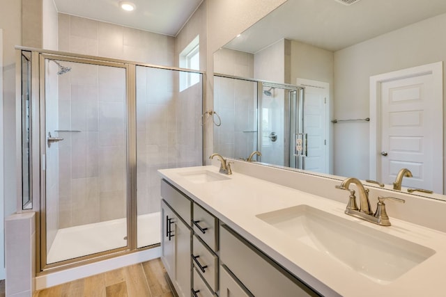 110 Denali Dr, Kyle, TX 78640 - full bathroom featuring double vanity, a shower stall, and wood finished floors