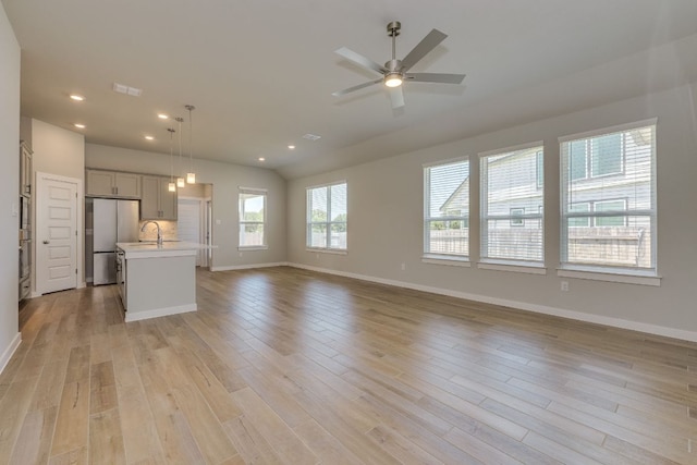110 Denali Dr, Kyle, TX 78640 - unfurnished living room with light wood-style floors, baseboards, a ceiling fan, recessed lighting, and lofted ceiling