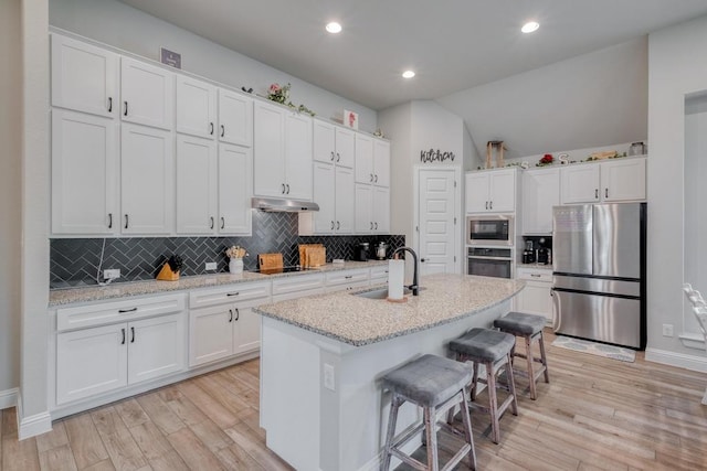 441 Double Eagle Ranch Dr, Cedar Creek, TX 78612 - kitchen featuring appliances with stainless steel finishes, a sink, under cabinet range hood, white cabinets, and light wood-style floors