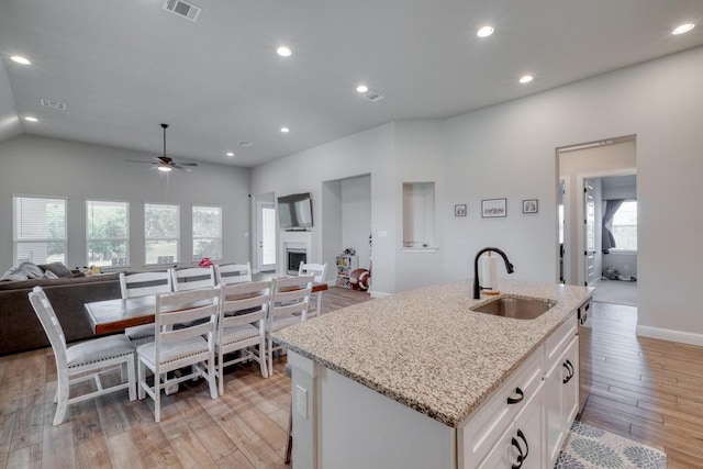 441 Double Eagle Ranch Dr, Cedar Creek, TX 78612 - kitchen featuring a sink, open floor plan, white cabinetry, a ceiling fan, and light wood-style floors
