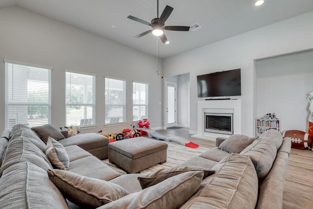 441 Double Eagle Ranch Dr, Cedar Creek, TX 78612 - living room featuring light wood-style floors, recessed lighting, a ceiling fan, a glass covered fireplace, and lofted ceiling