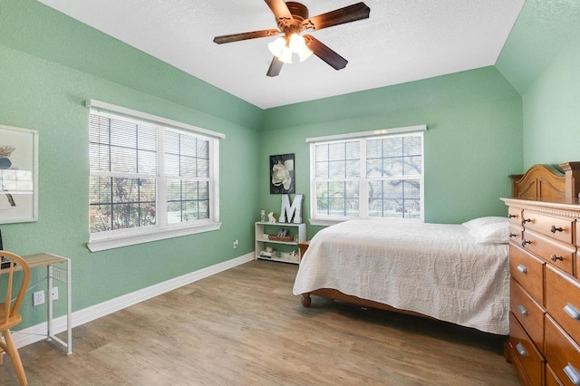 297 Carpers Trl, Fischer, TX 78623 - bedroom featuring wood finished floors, multiple windows, baseboards, and ceiling fan