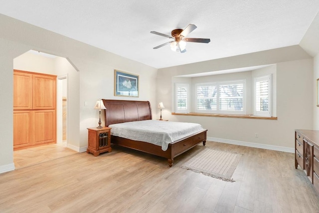 297 Carpers Trl, Fischer, TX 78623 - bedroom featuring light wood-style floors, baseboards, arched walkways, and a ceiling fan