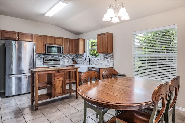217 Baldwin St, Hutto, TX 78634 - kitchen with appliances with stainless steel finishes, lofted ceiling, a chandelier, tasteful backsplash, and light countertops