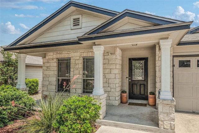 217 Baldwin St, Hutto, TX 78634 - entrance to property featuring covered porch, a garage, and stone siding