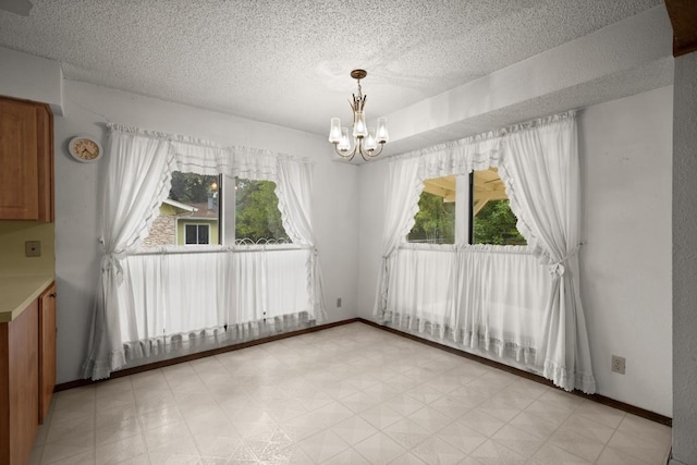 7104 Greenock St, Austin, TX 78749 - unfurnished dining area featuring a textured ceiling, a chandelier, light floors, and baseboards