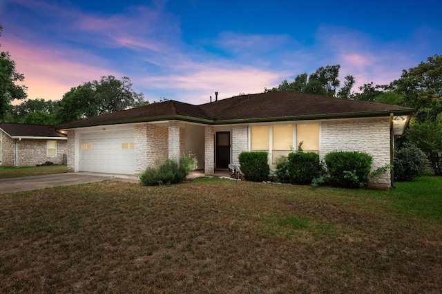 7104 Greenock St, Austin, TX 78749 - ranch-style house with stone siding, concrete driveway, an attached garage, and a yard