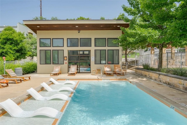 2724 Treble Ln Unit 324, Austin, TX 78704 - rear view of property featuring a storage structure, stucco siding, an outbuilding, a community pool, and a patio area