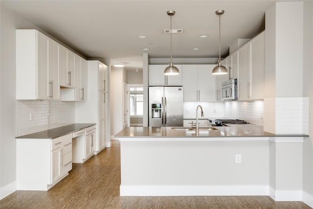2724 Treble Ln Unit 324, Austin, TX 78704 - kitchen with appliances with stainless steel finishes, a sink, a peninsula, tasteful backsplash, and decorative light fixtures