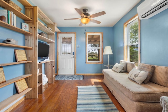 10843 US Highway 90 W, Harwood, TX 78632 - living room featuring an AC wall unit, hardwood / wood-style flooring, ceiling fan, and baseboards