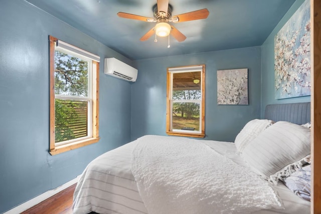 10843 US Highway 90 W, Harwood, TX 78632 - bedroom with a wall mounted air conditioner, multiple windows, baseboards, and wood finished floors