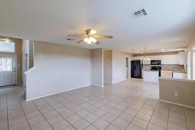 1214 Hensley Dr, Leander, TX 78641 - unfurnished living room with healthy amount of natural light, light tile patterned flooring, ceiling fan, a chandelier, and recessed lighting