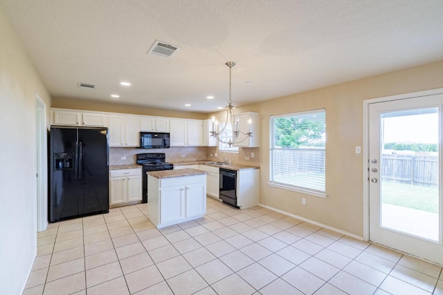1214 Hensley Dr, Leander, TX 78641 - kitchen with black appliances, a chandelier, tasteful backsplash, a sink, and white cabinetry