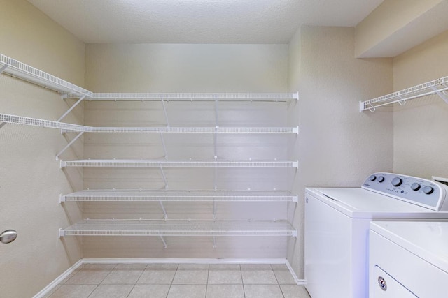 1214 Hensley Dr, Leander, TX 78641 - washroom featuring washer and clothes dryer, light tile patterned floors, baseboards, and a textured ceiling