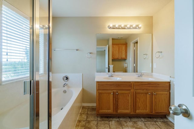 1214 Hensley Dr, Leander, TX 78641 - bathroom featuring a bath, double vanity, a stall shower, and baseboards