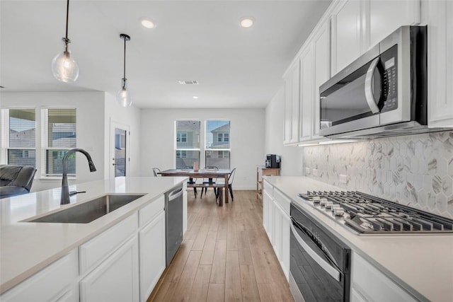 240 Harbors Ln, Leander, TX 78641 - kitchen featuring stainless steel appliances, a sink, light countertops, backsplash, and recessed lighting