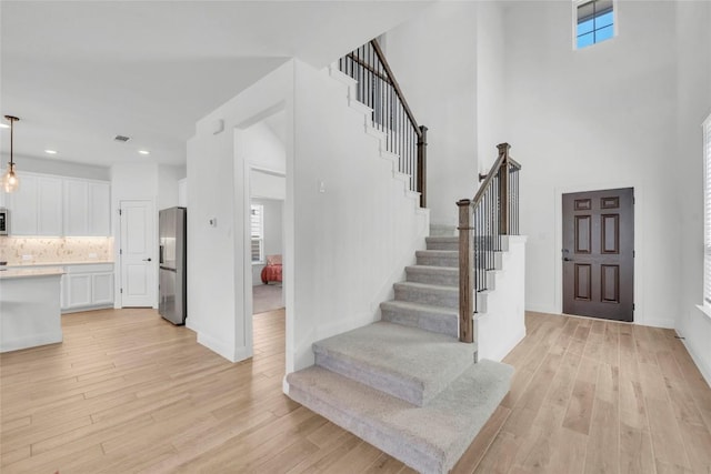240 Harbors Ln, Leander, TX 78641 - foyer entrance featuring stairway, light wood-style flooring, a high ceiling, recessed lighting, and baseboards