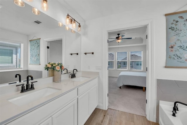 240 Harbors Ln, Leander, TX 78641 - full bath with double vanity, wood finished floors, a garden tub, ensuite bath, and ceiling fan