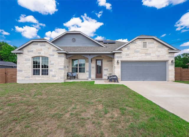 128 Naalehu Ct, Bastrop, TX 78602 - view of front facade with roof mounted solar panels, concrete driveway, roof with shingles, a garage, and stone siding