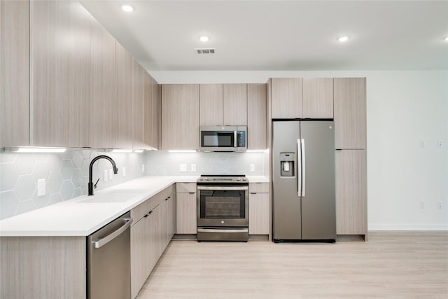 4802 S Congress Ave Unit 121, Austin, TX 78745 - kitchen with appliances with stainless steel finishes, modern cabinets, light wood finished floors, tasteful backsplash, and recessed lighting