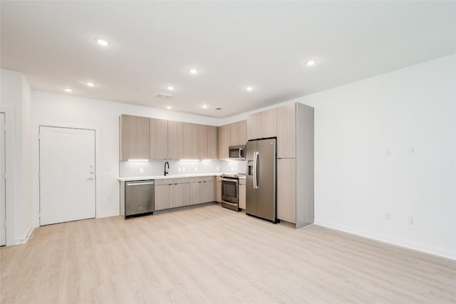 4802 S Congress Ave Unit 121, Austin, TX 78745 - kitchen with appliances with stainless steel finishes, light countertops, modern cabinets, light wood-style flooring, and recessed lighting