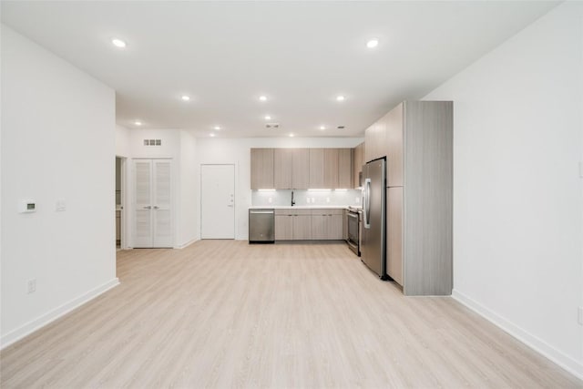 4802 S Congress Ave Unit 121, Austin, TX 78745 - kitchen featuring stainless steel appliances, light countertops, light wood finished floors, recessed lighting, and modern cabinets