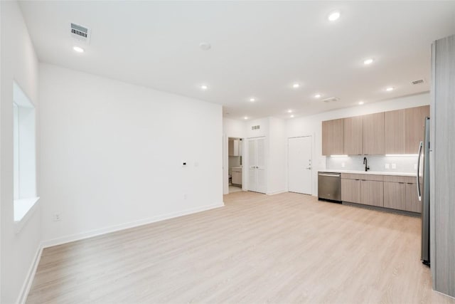4802 S Congress Ave Unit 121, Austin, TX 78745 - kitchen with stainless steel appliances, light wood-style floors, light countertops, modern cabinets, and recessed lighting