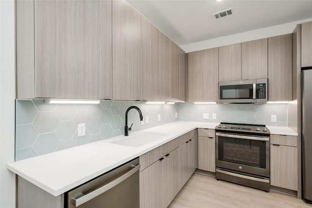 4802 S Congress Ave Unit 121, Austin, TX 78745 - kitchen featuring appliances with stainless steel finishes, light brown cabinetry, and modern cabinets