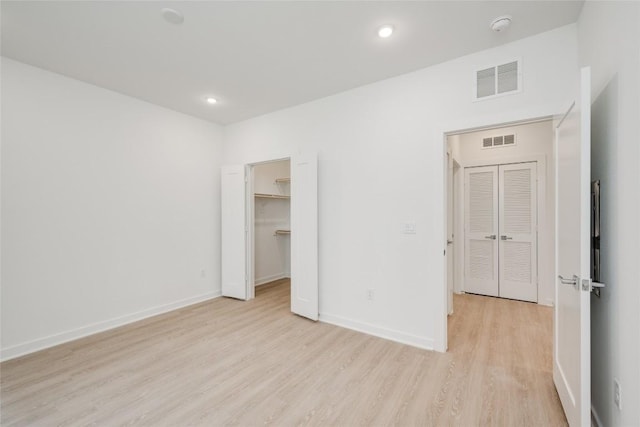4802 S Congress Ave Unit 121, Austin, TX 78745 - unfurnished bedroom with light wood-style floors, a spacious closet, and recessed lighting