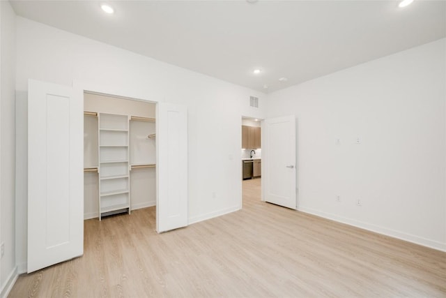 4802 S Congress Ave Unit 121, Austin, TX 78745 - unfurnished bedroom with light wood-style floors, a spacious closet, recessed lighting, and a closet