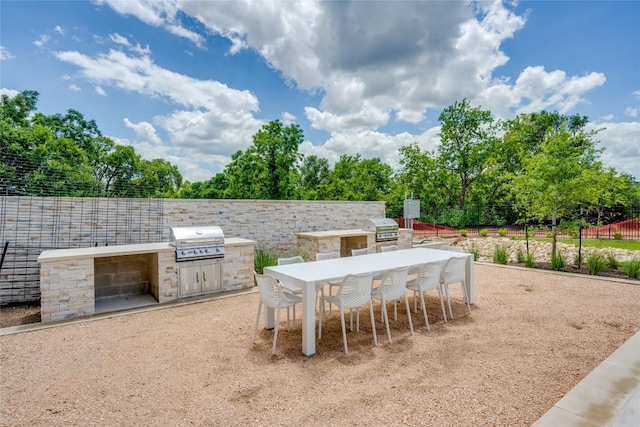 4802 S Congress Ave Unit 121, Austin, TX 78745 - view of patio with an outdoor kitchen, outdoor dining space, and view of wooded area