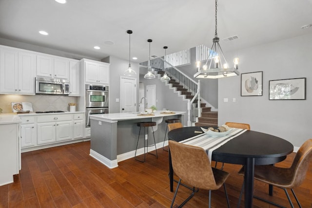 7820 Oteka Cv, Austin, TX 78735 - dining area featuring stairway, a chandelier, recessed lighting, dark wood finished floors, and baseboards