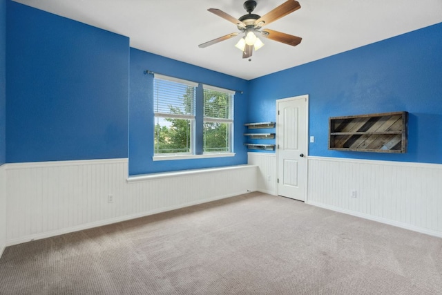 7820 Oteka Cv, Austin, TX 78735 - unfurnished room featuring a wainscoted wall, ceiling fan, and carpet flooring