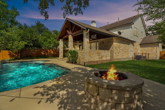 7820 Oteka Cv, Austin, TX 78735 - back of property with a patio, stone siding, an outdoor fire pit, and a ceiling fan