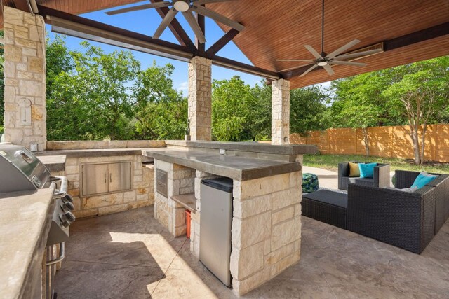 7820 Oteka Cv, Austin, TX 78735 - fenced backyard with a ceiling fan, area for grilling, a patio, and view of scattered trees
