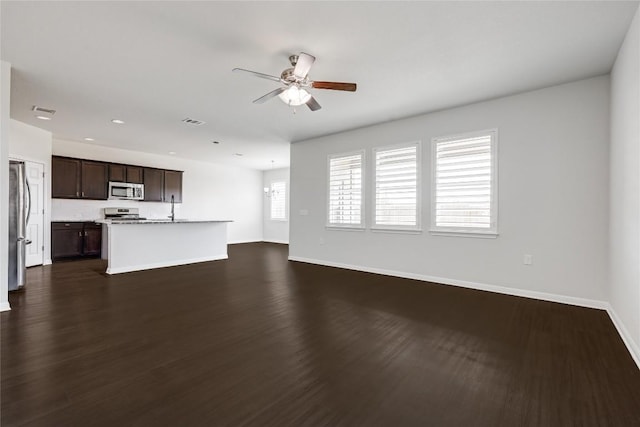 825 Fortrose Ter, Pflugerville, TX 78660 - unfurnished living room with a ceiling fan, baseboards, dark wood-type flooring, a sink, and recessed lighting